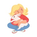 Blonde girl in red sweater is hugging white rabbit