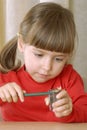 Blonde girl sharpening a pencil. Royalty Free Stock Photo