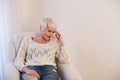 Blonde girl with short hair sits in a white armchair Royalty Free Stock Photo