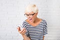 Blonde girl shouts in anger to her phone Royalty Free Stock Photo