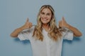 Blonde girl showing thumbs up gesture with both hands Royalty Free Stock Photo