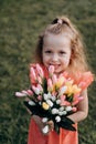 The blonde girl smiles beautifully with a bouquet of flowers in her hand Royalty Free Stock Photo