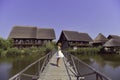 Blonde girl  standing on a wooden dock above the river Royalty Free Stock Photo