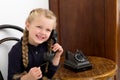 Blonde girl talking by old black phone Royalty Free Stock Photo