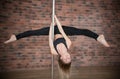 Blonde girl training pole dance in a studio Royalty Free Stock Photo