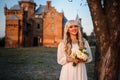 Blonde girl in a white dress on nature near architectural monuments in the open air