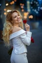 Blonde girl in white dress with rose in her hand. Royalty Free Stock Photo