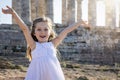 A blonde girl in a white summer dress in front of an ancient, Greek temple Royalty Free Stock Photo