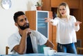 Blonde girl yelling at black boyfriend as quarreling indoors