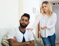 Blonde girl yelling at black boyfriend as quarreling indoors