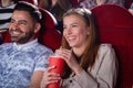 Blonde in gray and Arabian man in blue in cinema. Royalty Free Stock Photo