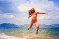 Blonde gymnast in bikini jumps over sea face closed with hair Royalty Free Stock Photo