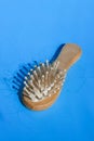 Blonde hair loss problem with hairbrush on blue background. Alopecia, hair problem, falling hair on brush healthy