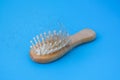 Blonde hair loss problem with hairbrush on blue background. Alopecia, hair problem, falling hair on brush healthy
