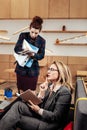Blonde-haired businesswoman giving tasks to young helpful secretary