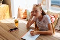 Blonde-haired teenager feeling bored while doing homework