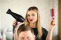 Blonde Hairstylist Showing Blow Dryer and Comb