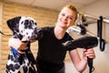 blonde happy woman blowing dry the dalmatian dog hair wiping with a bath towel in the grooming salon Royalty Free Stock Photo