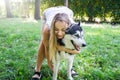 Attractive blonde hugs her dog in the park. Royalty Free Stock Photo