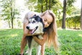 Attractive blonde hugs her dog in the park. Royalty Free Stock Photo