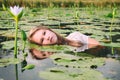 Blonde lady floating amongst the lillies