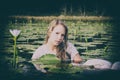 Blonde lady floating amongst the lillies