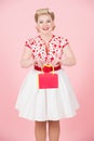 Young beautiful girl holds red box isolated in studio on pink background. Royalty Free Stock Photo