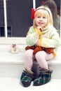 Blonde little girl in knitted sweater sitting Royalty Free Stock Photo