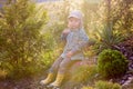 Blonde little toddler child with binoculars, sitting in garden on sunset Royalty Free Stock Photo