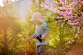 Blonde little toddler child with binoculars, sitting in garden on sunset Royalty Free Stock Photo