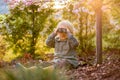 Blonde little toddler child with binoculars, sitting in garden on sunset Royalty Free Stock Photo