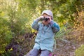 Blonde little toddler child with binoculars, sitting in garden on sunset Royalty Free Stock Photo