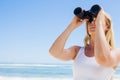 Blonde looking through binoculars on the beach Royalty Free Stock Photo