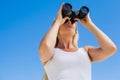 Blonde looking through binoculars on the beach Royalty Free Stock Photo