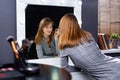 A blonde make-up artist makes herself a professional make-up while looking in a large illuminated mirror. The concept of beauty Royalty Free Stock Photo