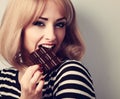 Blonde makeup woman eating dark chocolate with look. Short