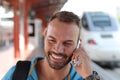 Blonde man calling by phone from train station Royalty Free Stock Photo