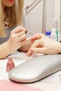 Blonde manicurist polishing fingernails