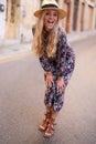 Blonde Mediterranean urban woman floral pattern dress posing