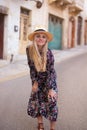 Blonde Mediterranean 20s woman floral pattern dress posing