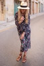 Blonde Mediterranean woman floral pattern dress posing on street