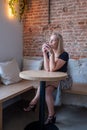 Blonde Millennial Woman Enjoying Coffee in Cafe Royalty Free Stock Photo