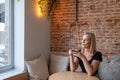 Blonde Millennial Woman Enjoying Coffee in Cafe Royalty Free Stock Photo