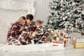 Mother, father and daughter sitting on s floor near Christmas tree Royalty Free Stock Photo