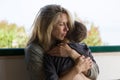 Blonde mother hugs her brunette boy with deep love Royalty Free Stock Photo