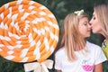 Blonde Mum Kissing Her Daughter. Girl Holding Big Chupa Chups Royalty Free Stock Photo