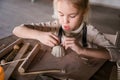 Blonde girl sculpts from clay with interest