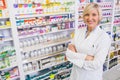 Blonde pharmacist with arms crossed smiling at camera Royalty Free Stock Photo