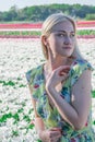 Sexy blonde at a photo shoot in a field of flowers and tulips Holland