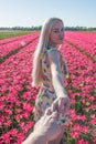 Sexy blonde at a photo shoot in a field of flowers and tulips Holland